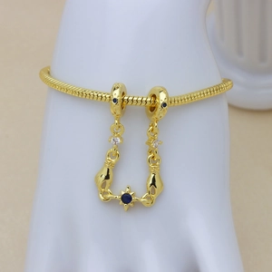 Golden snake chain bracelet with blue gemstones and unique hand-shaped pendant charms