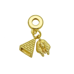 Macro shot of gold-plated pyramid and Egyptian Pharaoh pendants on a snake chain link