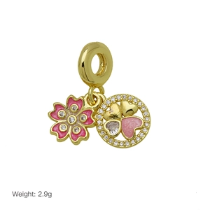 Detail view of 18K gold plated flower and heart charm with pink enamel and zircons