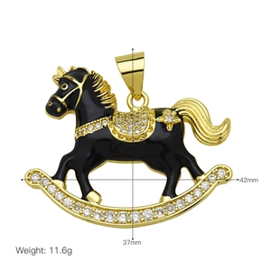 Golden rocking horse pendant with black enamel and sparkling zircon stones on white background