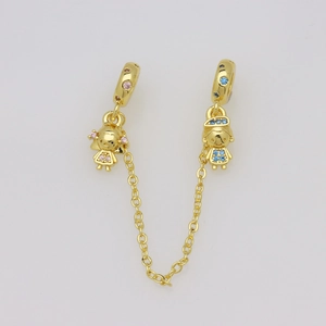 Dettaglio dei ciondoli bambino e bambina placcati in oro con cristalli rosa e blu lucidi