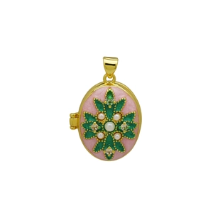 Detailopname van een ovale locket met roze emaille en parels op goudkleurig metaal