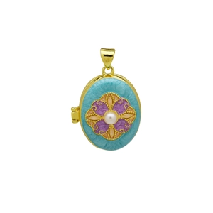 Detail van een vintage gouden medaillon met blauwe emaille bloem en parelinleg
