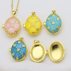 Detalle de relicario ovalado chapado en oro 18K con flores de esmalte y bisagra de apertura