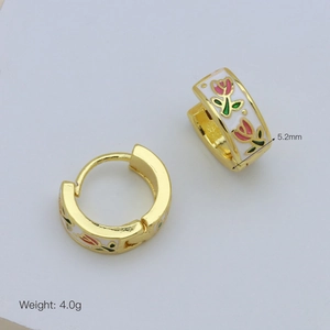 Dettaglio degli orecchini huggie placcati oro 18 carati con smalto bianco e tulipani