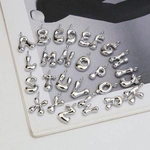 Macro shot of silver balloon style 3D initial letter pendants with a polished metallic finish