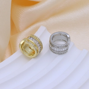 Dettaglio macro di ear cuff in ottone oro e argento con file di zirconi incastonati