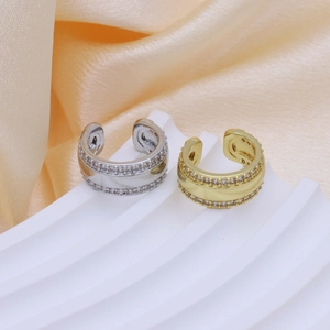 Dettaglio dei polsini auricolari in ottone dorato e argento con zirconi micro-pavé