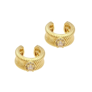 Dettaglio macro di orecchini ear cuff in ottone dorato con zircone ovale e coste