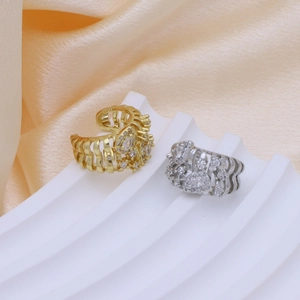 Dettaglio macro di anelli traforati placcati oro e argento con pietre di zircone a cuore