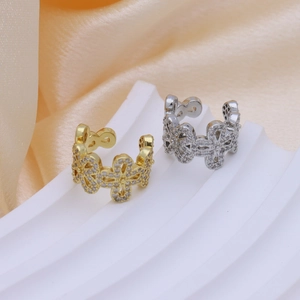 Dettaglio dei polsini per orecchie a fiore in oro e argento con cristalli di zircone