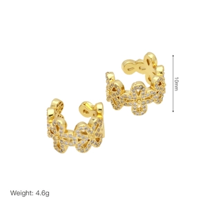Dettaglio macro di ear cuff a fiore placcati in oro con zirconi bianchi e misura 10mm