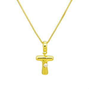 Vue macro détaillée du pendentif lettre T en or poli incrusté d'une perle délicate