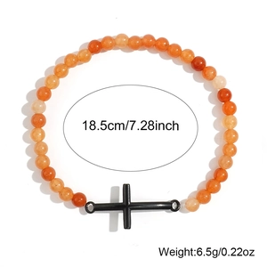 Primer plano detallado de la pulsera de cuentas naranjas de 6 mm con dije de cruz negra
