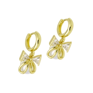 Macro detail of gold bow pearl earrings featuring sparkling zircon inlay in a luxury style