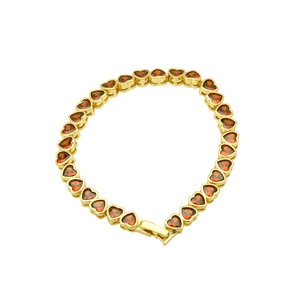 Detail view of a gold-plated bracelet featuring continuous red heart-shaped zircon stones