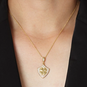 Gold shield necklace with lucky clover pendant and sparkling cubic zirconia crystals for women