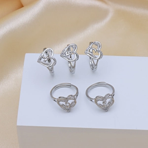 Silver heart rings set with zircon and A-E initials on luxury champagne silk display