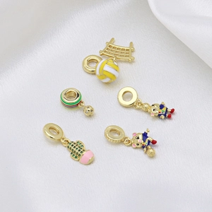 Golden sports-themed charms with enamel and zircons on elegant white silk background