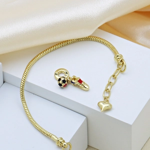 Goldenes Schlangenarmband mit Fußball- und Schuhanhänger auf weißem Ständer präsentiert