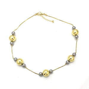 Collier à perles bicolore minimaliste avec boules dorées et argentées sur fond blanc