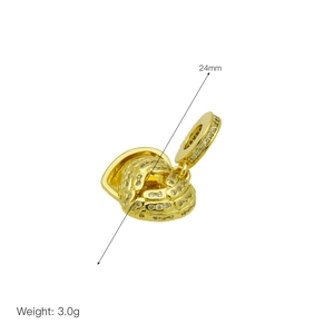 Détail macro d'un pendentif cœur doré 24mm avec textures évidées et zircons blancs