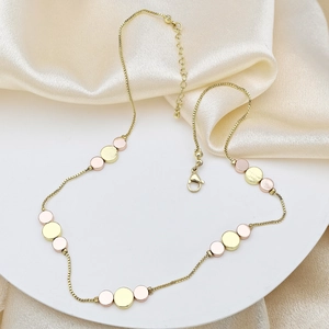 Vue détaillée des breloques disques tricolores sur un collier chaîne box dorée avec fermoir