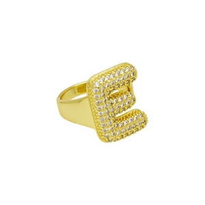 Macro-detail van gepolijste gouden ring met kristallen pavé-gezette letter E