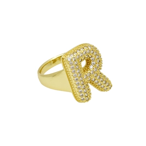Macro-opname van gepolijste gouden ring met micro-pave zirkonia letter R ontwerp