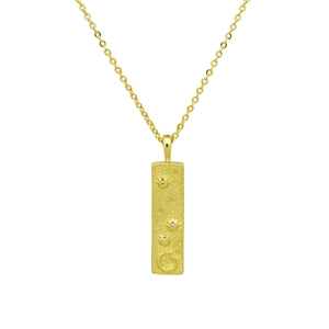 Détail d'un pendentif rectangulaire plaqué or 18k avec gravures du soleil et de la lune