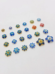 Makroaufnahme bunter Emaille-Blumenzwischenperlen und Perlenkappen für DIY-Schmuck