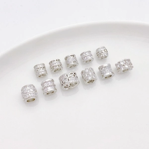 Vista macro de cuentas cilíndricas de plata con circonitas para crear joyas DIY