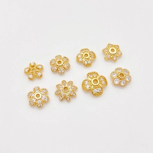 Vista macro de espaciadores florales chapados en oro 18K con circonitas para joyería DIY