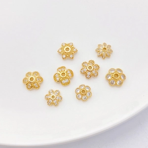 Detalle de cuentas espaciadoras florales bañadas en oro 18K con circonitas para joyería