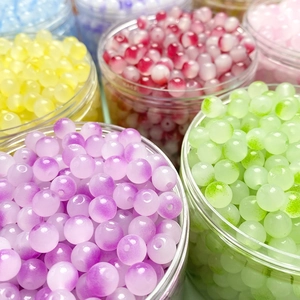 Macro-opname van kleurrijke 8mm matte glazen kralen in potten voor DIY-handwerkprojecten