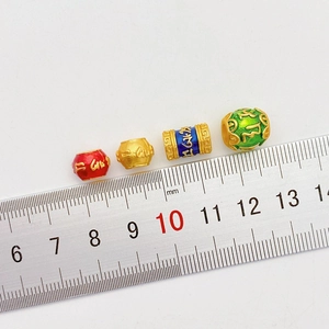 Detalle macro de cuentas de mantra doradas esmaltadas para creación de joyas DIY