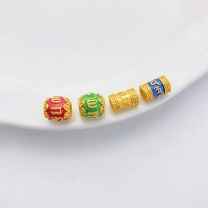 Detalle macro de cuentas de oro antiguo con mantra de seis sílabas y esmalte de colores