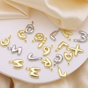 Golden and silver bubble letter pendants with puffy balloon design on white stage