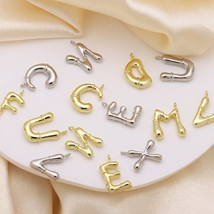 Bamboo style gold and silver alphabet initial pendants set on elegant silk fabric