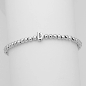 Dettaglio di bracciale a sfere argentate con ciondolo lettera D su supporto