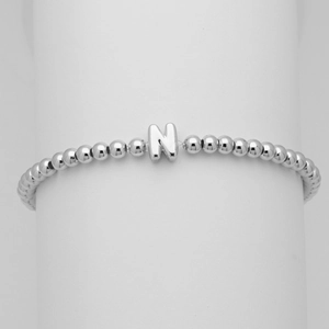 Dettaglio del bracciale con perline argentate e ciondolo a lettera N stile palloncino