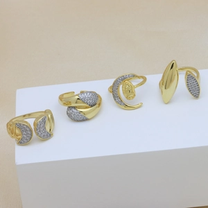 Set of gold rings featuring moon designs and sparkling cubic zirconia on a white display stand