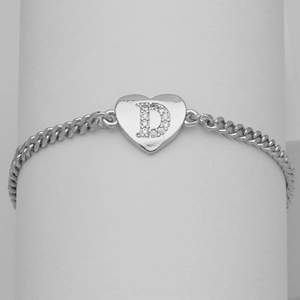 Macro detail of silver heart charm with cubic zirconia letter D on a curb chain