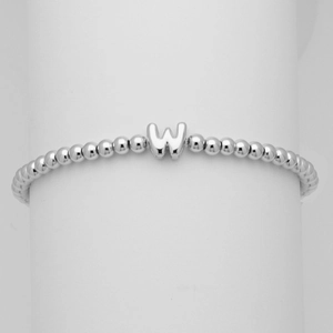 Dettaglio di un bracciale a sfere argentate con un ciondolo a forma di lettera W a bolla