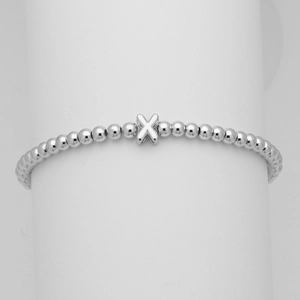 Dettaglio del bracciale a sfere argentate con un lucido ciondolo a forma di lettera X