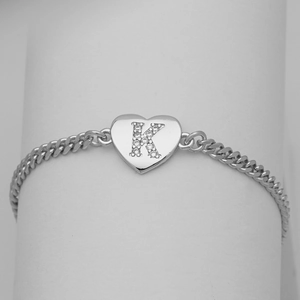 Detail of silver Cuban chain bracelet featuring a heart pendant with zircon letter K