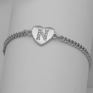 Detail shot of heart-shaped letter N pendant with pavé cubic zirconia on curb chain