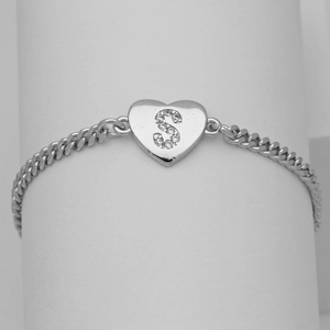 Detail of silver Cuban chain bracelet featuring a heart pendant with pavé letter S