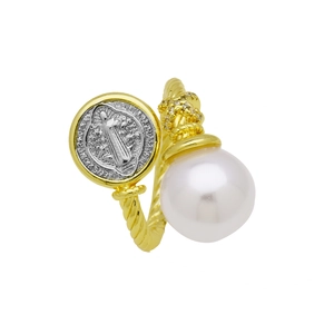 Detail of a vintage twisted gold ring with a white pearl and Saint Benedict medal