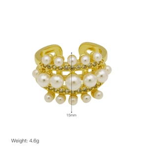 Detailed view of multilayer gold ring with inlaid rhinestones and white pearls